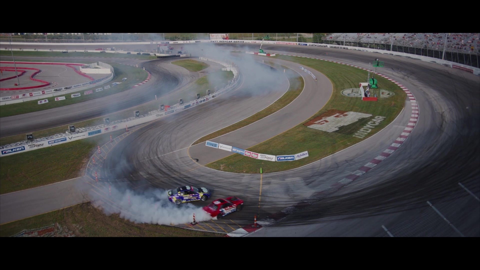 Dwa samochody podczas driftu na torze, kadr z filmu Formula Drift